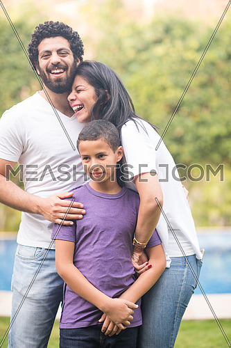 Portrait of a young middle east couple with their son in the yard by the pool