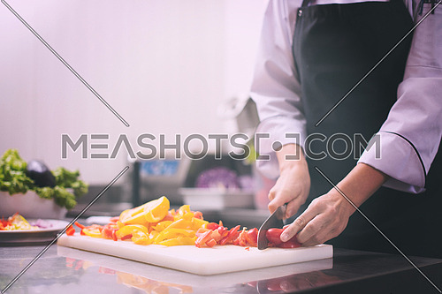 Chef cutting fresh and delicious vegetables for cooking or salad