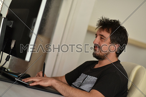 graphic designer working on a digital tablet and a computer