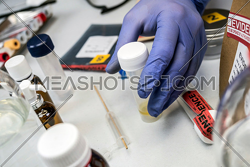 Scientific Police hold evidence of a crime in scientific lab, conceptual image