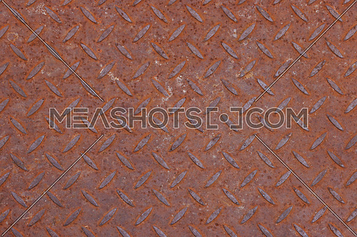 Background texture of rusty corroded weathered industrial anti slip embossed metal steel plate surface with diagonal bumps of diamond pattern, close up