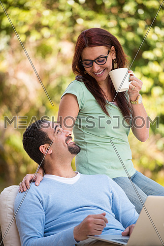 Young Middle Eastern couple enjoying your morning coffee in the garden sunny summer morning