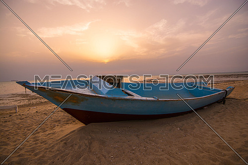 An abandoned boat on a sand beach