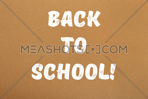 Back to school white paint handwritten sign over brown parchment paper background with copy space