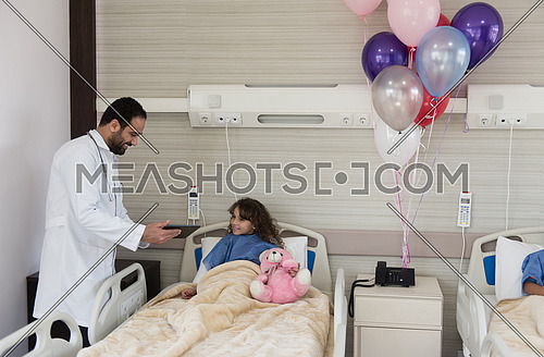 arabian mischievous and beauty kid get treatment by young doctor in modern hospital room