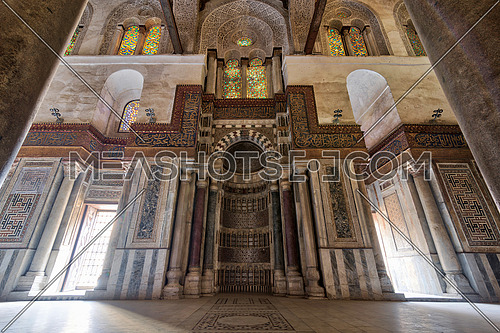 Mausoleum of Sultan Qalawun with decorated colorful marble niche (Mihrab) embedded in ornate marble wall, and colorful stain glass windows, Moez Street. Cairo, Egypt