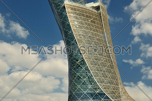 modern building of steel and glass facade with blue sky and clouds in background