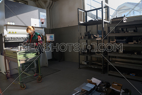 woman working in a modern factory and preparing material for a CNC machine. High quality photo