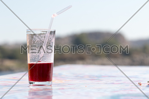 Glass of cold hibiscus and a straw in it