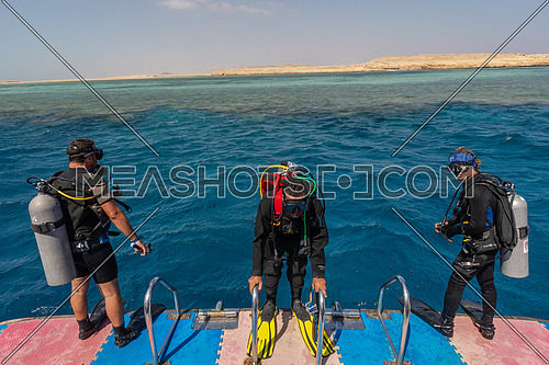 Long shot for divers getting ready to dive into Red Sea from a yacht at day