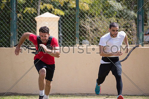 two young middle eastern athletic built men train running on the pitch on a sunny day