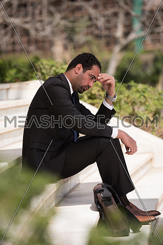 Frustrated business executive sitting on the stairs