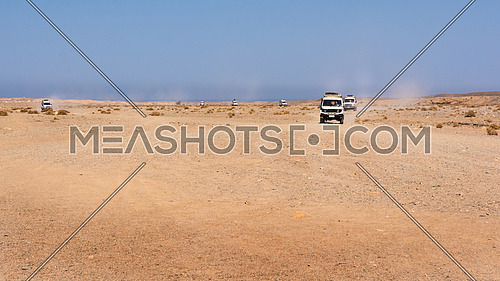 Egypt, Black Desert. Moving off-road vehicle with a panoramic view on the stone desert . Tracks on the sand from the automotive rubber.