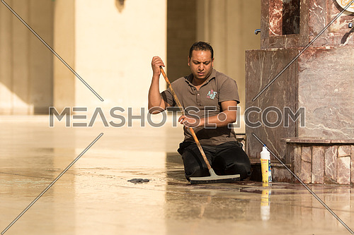 A janitor is cleaning the marble floor of Al-Hakim mosque in Al-Moez street, old Cairo