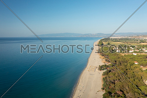 Drone shot of beautiful sea and beach with parasol at sunny day, Simeri Mare, Calabria, Southern Italy