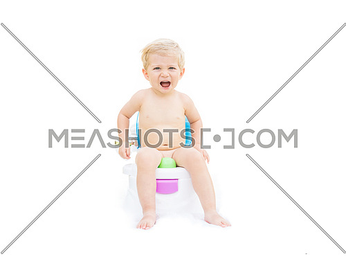 Infant boy, white caucasian smiling and sitting on the potty with white background.