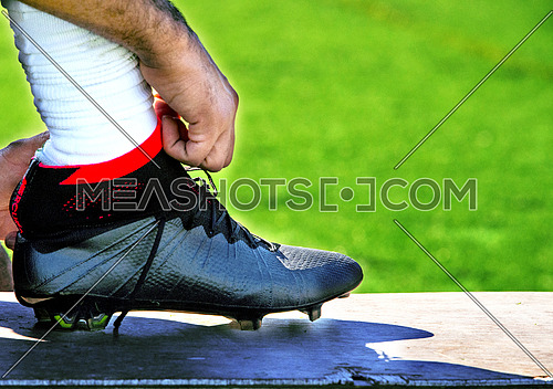 A close up on  football sports shoe athlete tying his shoe lace