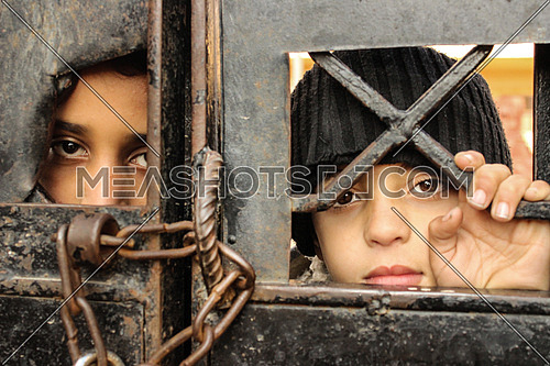 Two Syrian children standing in front of a school gate for refugees in Cairo Egypt
