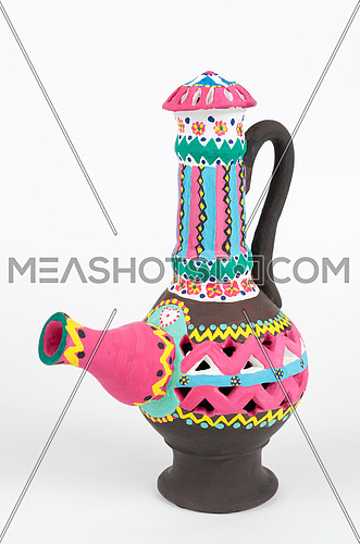 Front view of Nubian style decorated colorful handcrafted pottery jug on white background