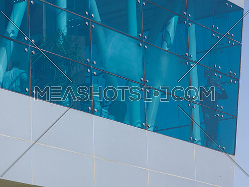 senior business man talking  on mobile phone  at modern office building outdoor shoot with blue sky in background