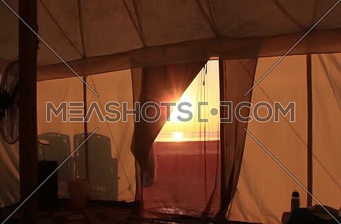 Long shot inside tent towards the sun and shore at sunset at Wadi Lahmi - 5D