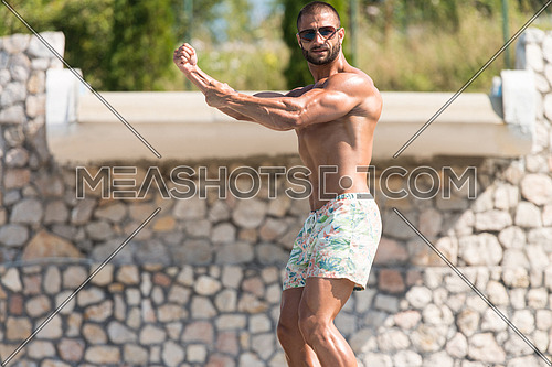 Portrait Of A Physically Fit Man Showing His Well Trained Body Outdoors In Summer Time