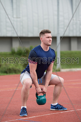 Young Man Working Out With Kettle Bell Exercise Outdoor