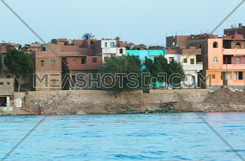 Long shot for Country side houses beside river Nile
