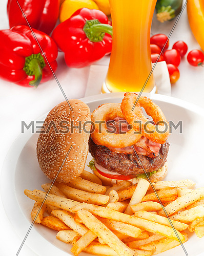 classic american hamburger sandwich with onion rings and french fries,glass of  beer and fresh vegetables on background,  MORE DELICIOUS FOOD ON PORTFOLIO
