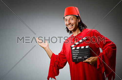 Man wearing fez hat with movie board