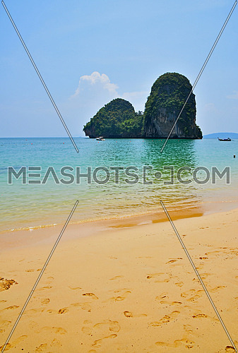 Paradise tropical sunny sand sea beach with sky blue water and forest rock