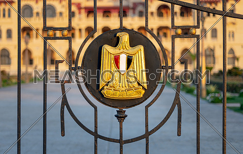 Logo of Egypt on an iron fence revealing Montaza Presidential Palace, consists of Golden Eagle of Saladin holding a scroll with Arabic text (Arab Republic of Egypt) and a shield with the flag's colors