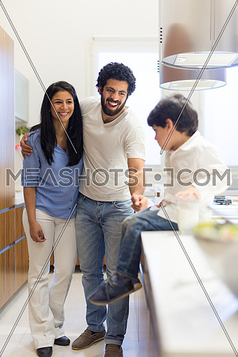 young middle east father and mother with son spend cheerful time in the kitchen