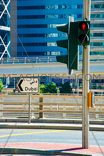 A street sign written on it Dubaiat a traffic intersection