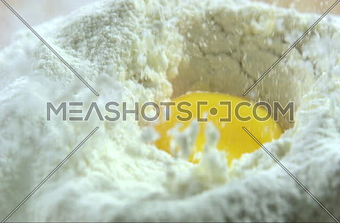 Close up Shot in Slow Motion for an egg falling in Flour