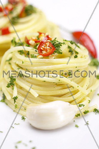 pasta garlic olive oil and red chili pepper closeup on a white dish