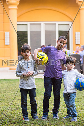 portrait of middle eastern boys with a ball sunny summer day in the yard