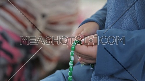 Close up shot for Young Muslim girl's Hands with rosary praying