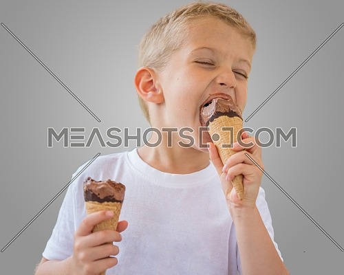 Baby boy kid eating chocolate ice cream in waffles cone isolated on gray background with free text copy space