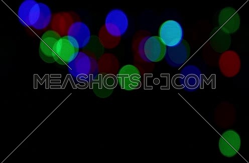 Colorful multicolor festive Christmas circular bokeh over dark, blue, green and red lights slow moving trembling and shaking, abstract background