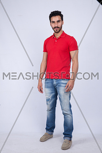A young man wearing red t-shit posing on a white background