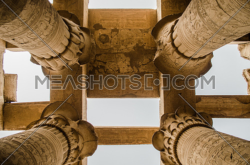 The top of a ceiling of Kom Ombo Pharaoh temple held on a huge columns decorated in a Papyrus shape at the top