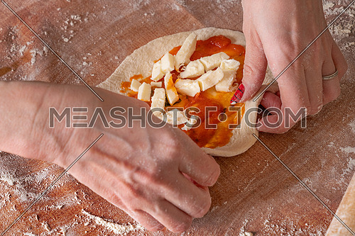 Making dough by female hands brown table background,view from above.
