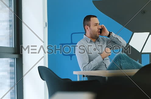 Man using phone in statup office enviroment