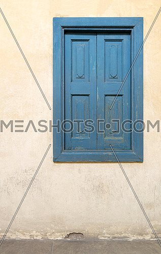 Blue wooden window of a old historic building with vintage plaster wall, Medieval Cairo, Egypt