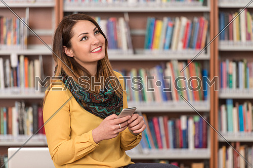 Female Student Talking On The Phone In Library - Shallow Depth Of Field