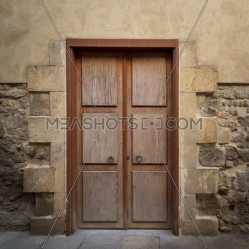 Wooden aged door on grunge stone bricks wall, Medieval Cairo, Egypt