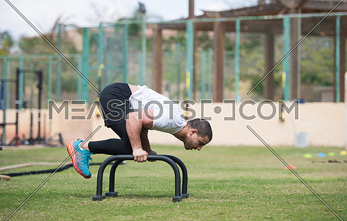 young middle eastern athletic man workout handstand outside on a sunny day