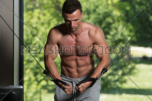 Muscular Young Man Bodybuilder Doing Heavy Weight Exercise For Chest On Cable Machine