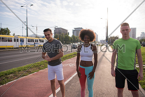 multiethnic group of young people on the jogging beautiful morning as the sun rises in the streets of the city